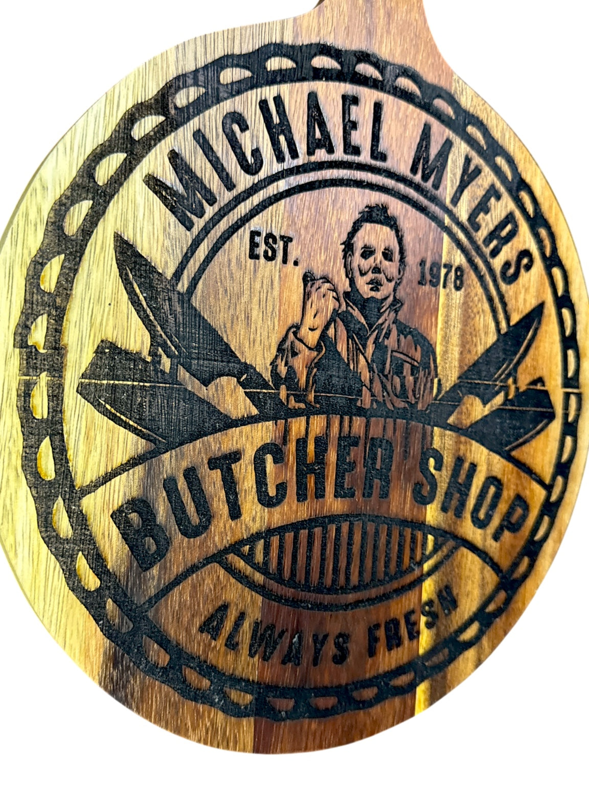 Angled view of Michael Myers Butcher Shop Oopsie engraved acacia board