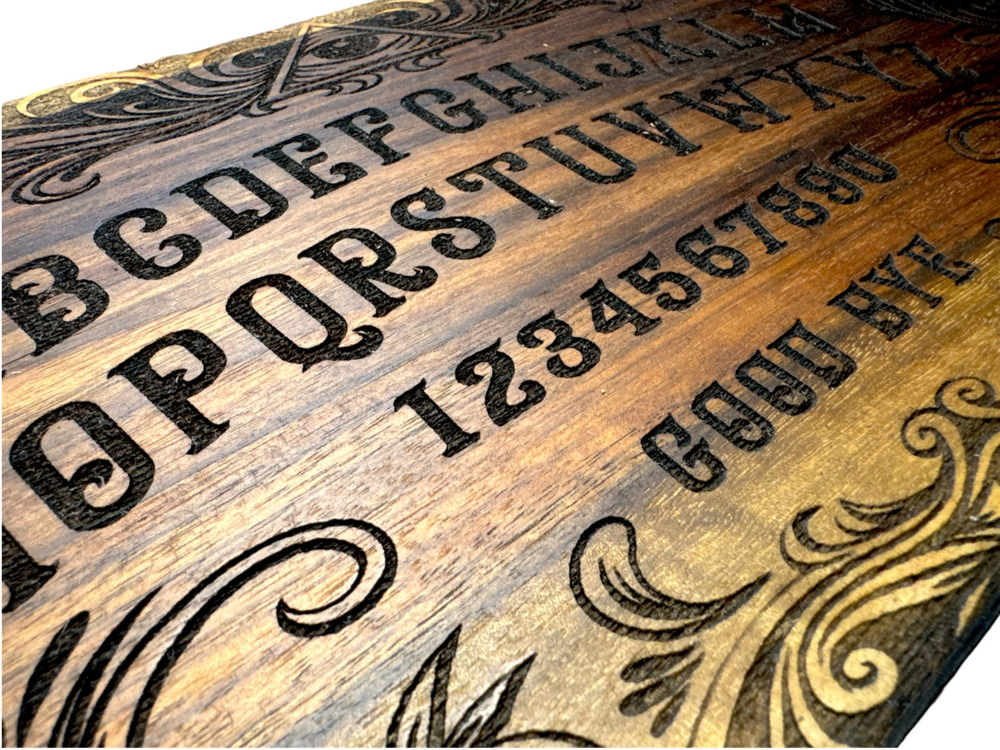 Close detail of laser engraving on finished walnut Ouija inspired spirit board