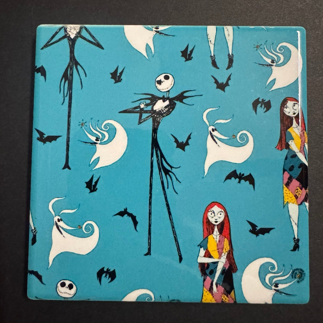 Square ceramic coaster with a whimsical spooky couple pattern, ghosts and bats on teal