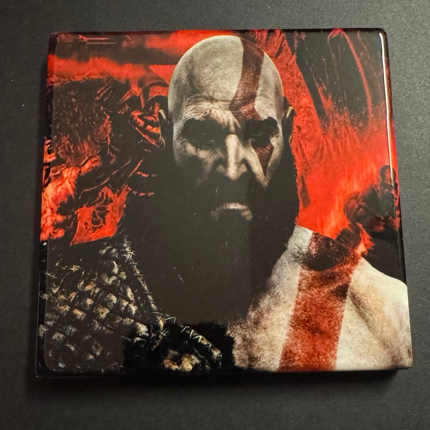 Square ceramic gaming coaster featuring an ash-covered warrior with red markings against a fiery background