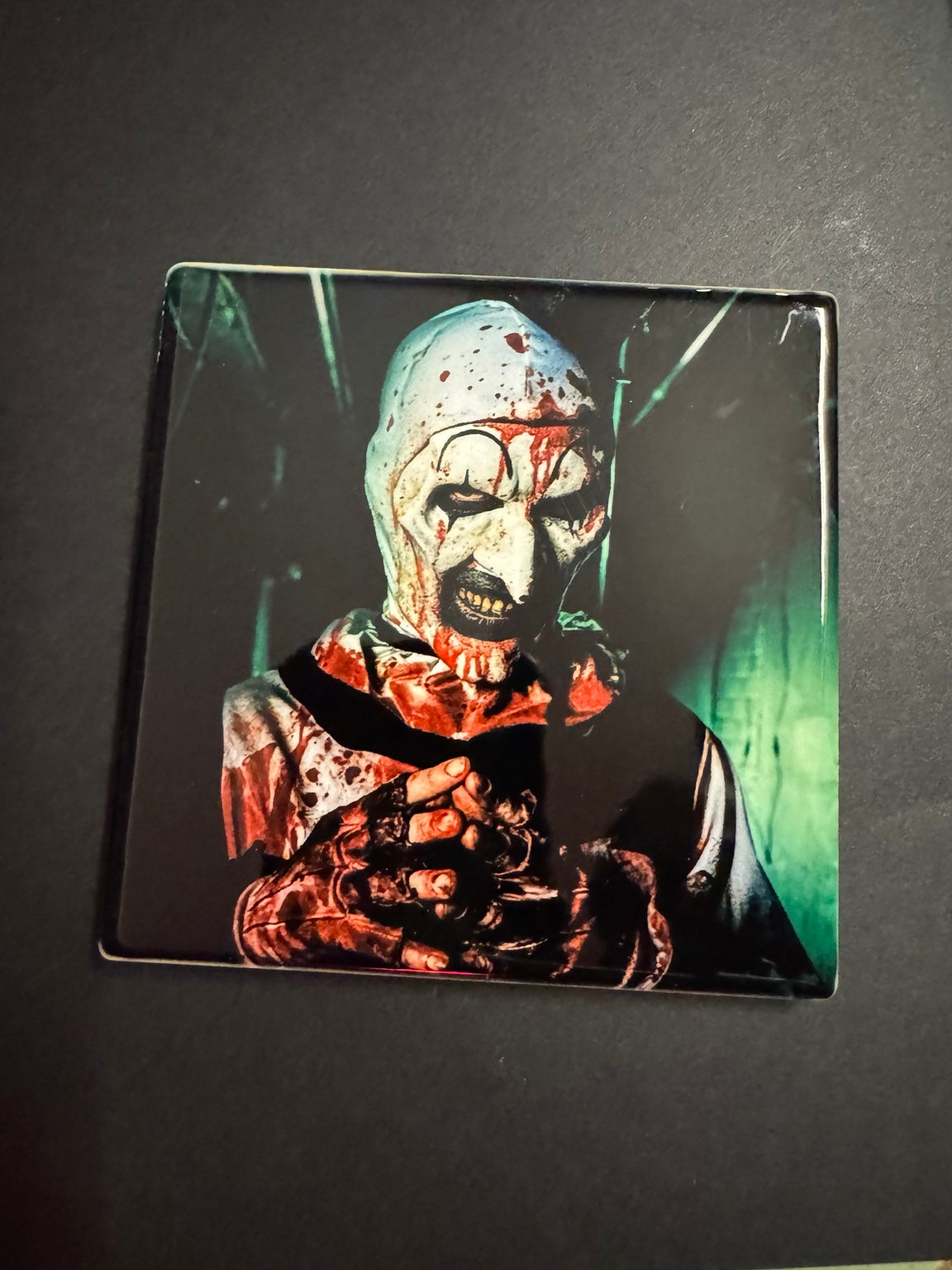 Square horror coaster featuring a bloodied black and white killer clown