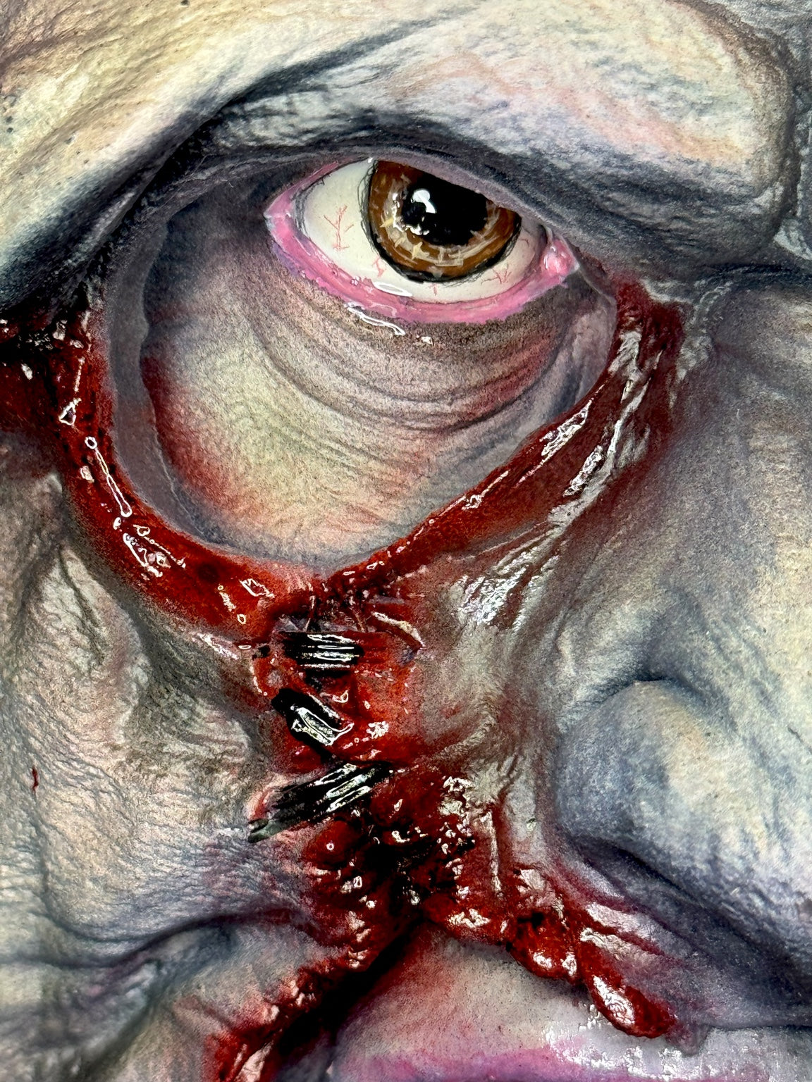 Close-up painted eye and stitched facial detail on Leatherface horror bust