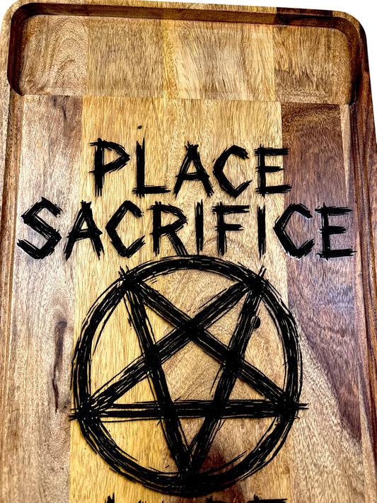 Close detail of Place Sacrifice Here pentagram engraving on acacia cutting board
