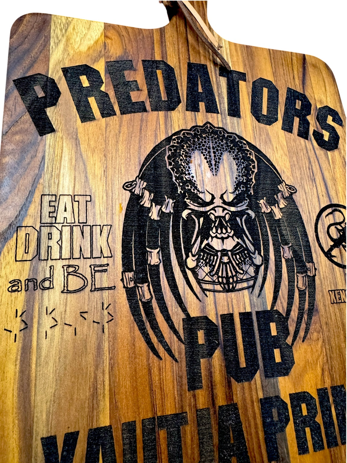 Close detail of Predator themed laser engraving on wood board