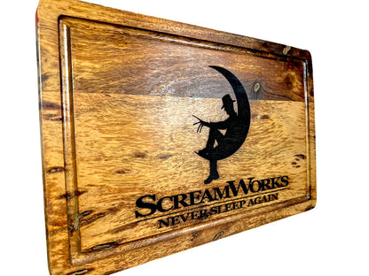 Angled view of ScreamWorks Freddy Krueger inspired acacia cutting board